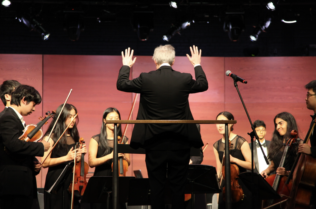 SHS orchestra director Amedee Williams seats SHS Chamber Orchestra before performance.